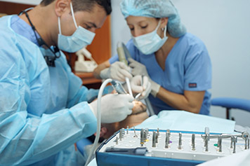 Fotografía de dos dentistas tratando la boca de un paciente