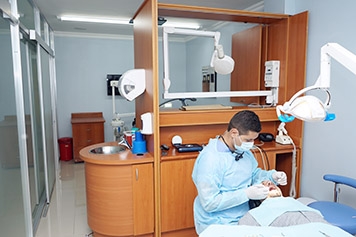 Fotografía de nuestro local. Uno de nuestros dentistas trabaja en la boca de un paciente