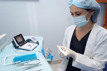 Photograph of a female dentist examining our equipment